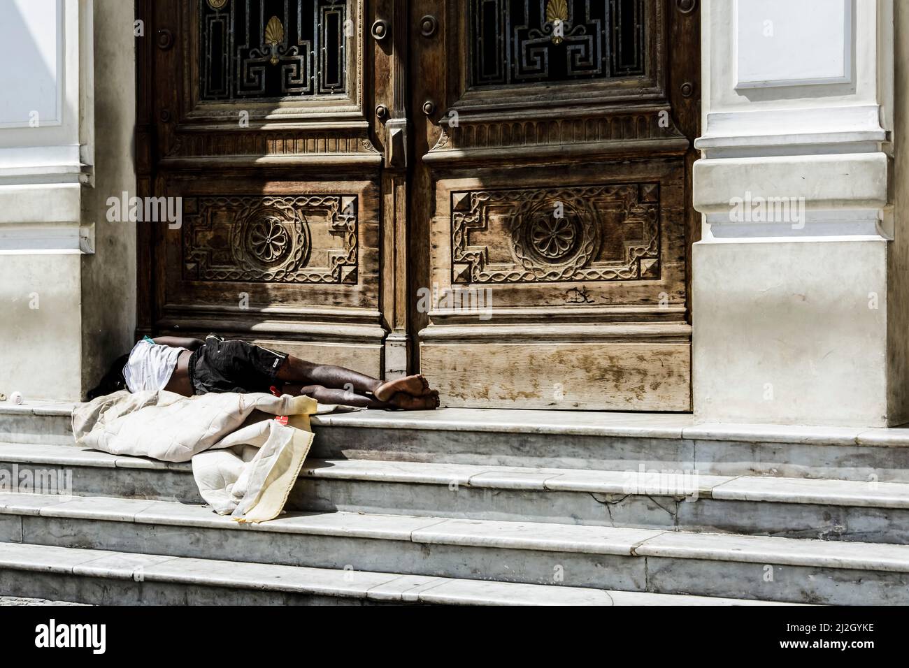 Homeless man sleeping at the door of a historic building in the city of Salvador, capital of Bahia, Brazil Stock Photo