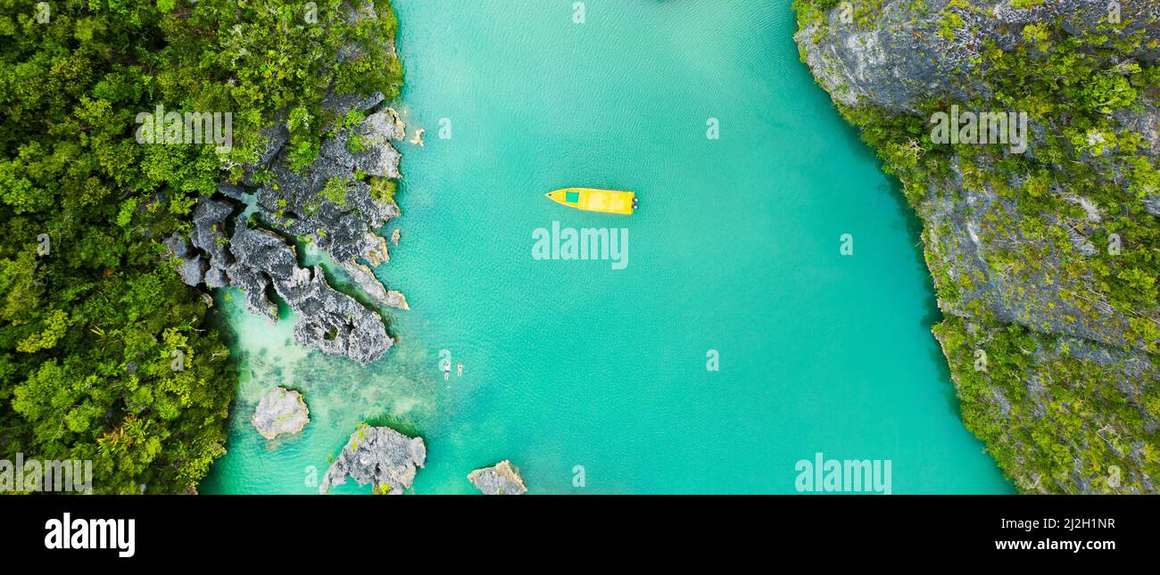 Kick off your summer with an island cruise. High angle shot of a boat sailing through a canal running along the Raja Ampat Islands in Indonesia. Stock Photo