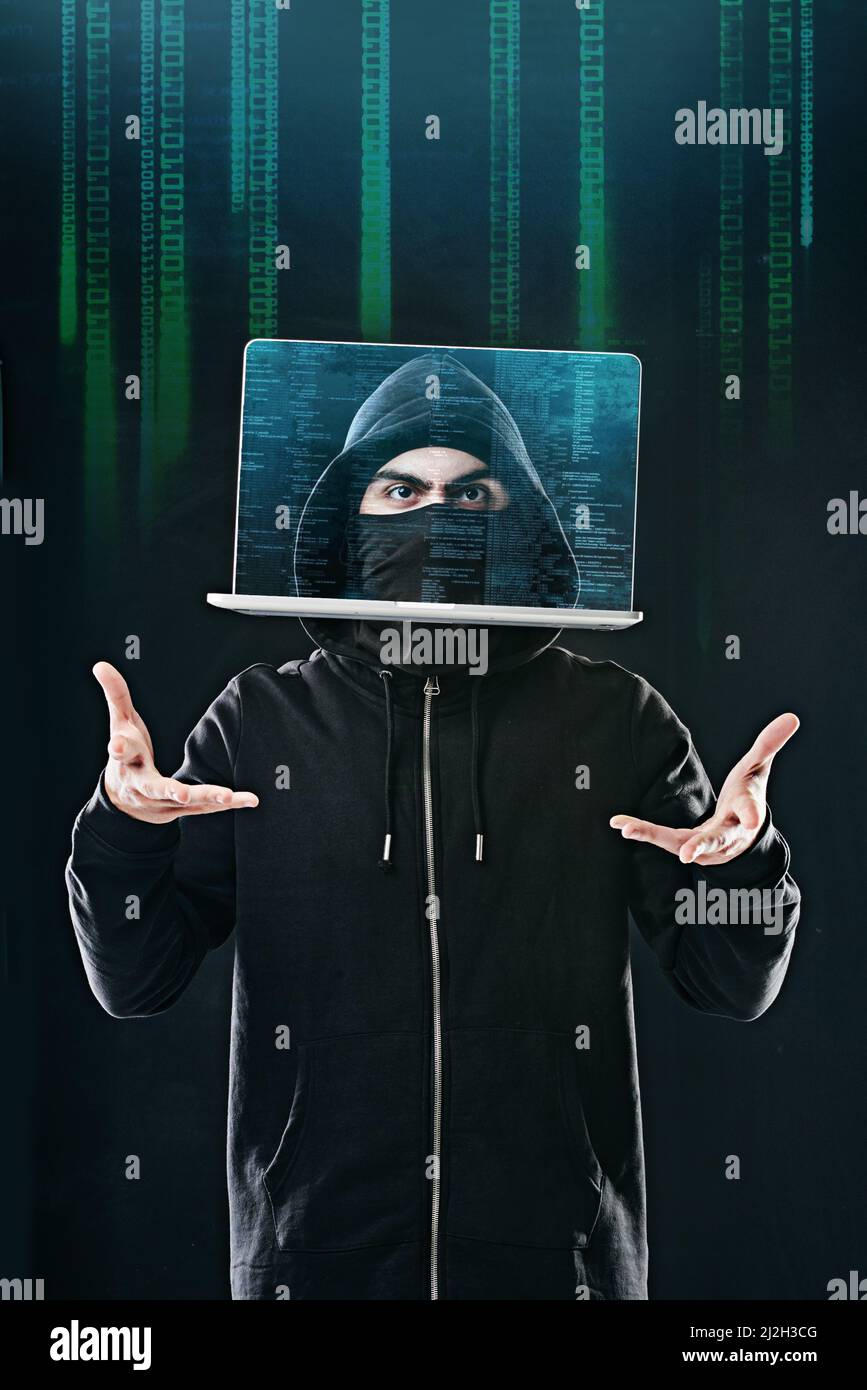 Bending your data to his will. Portrait of a computer hacker levitating a laptop while standing against a dark background. Stock Photo