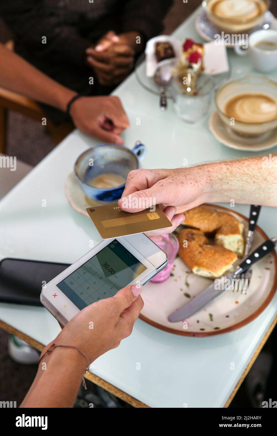 Close-up of man paying with credit card in restaurant Stock Photo