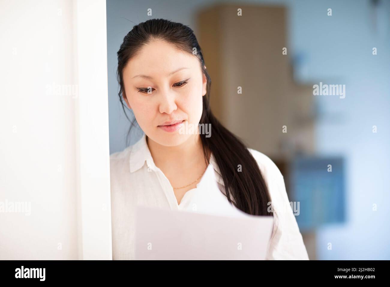 Serious businesswoman looking at documents in office Stock Photo