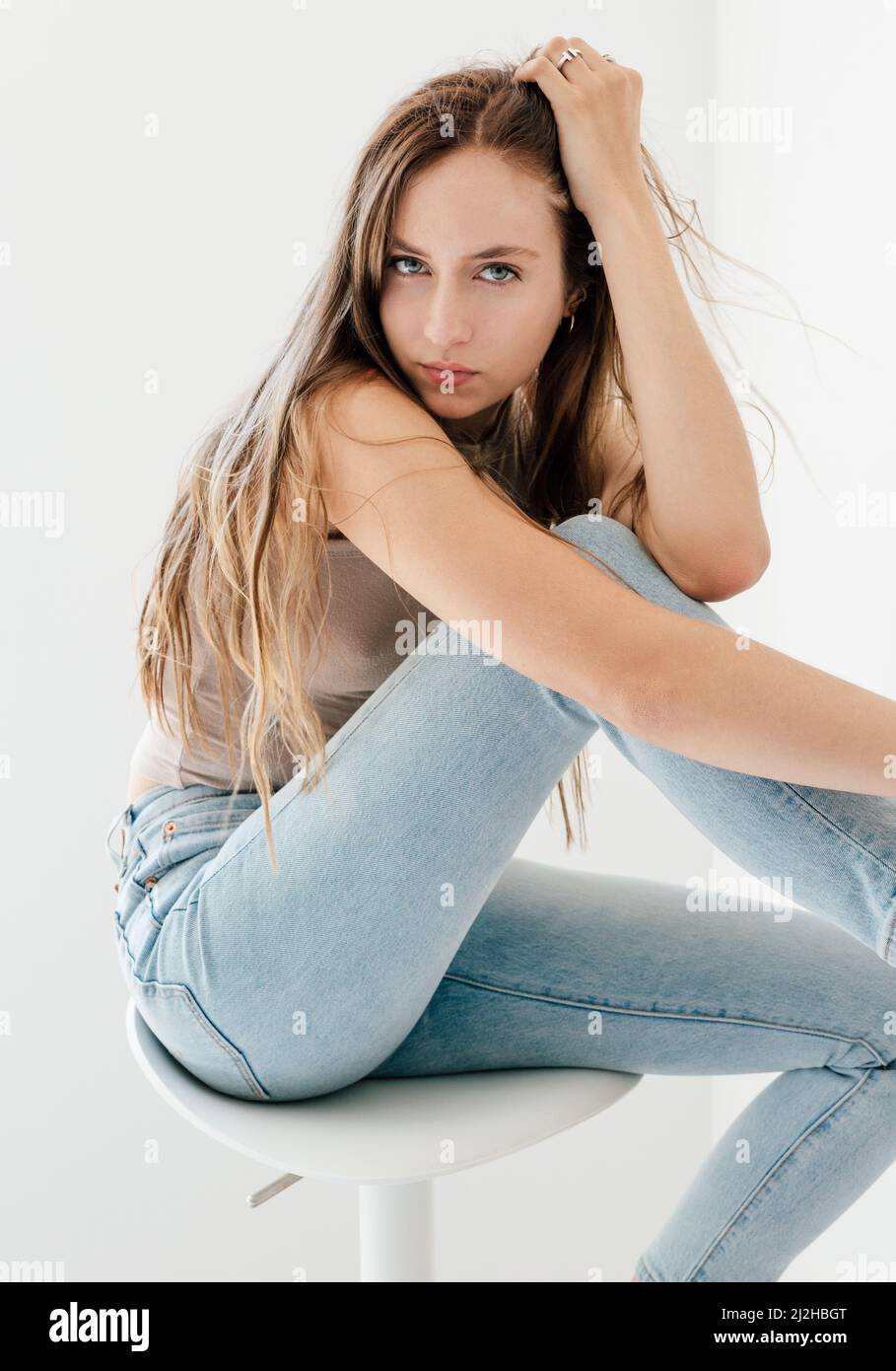 Studio portrait of blonde woman in skinny jeans Stock Photo - Alamy