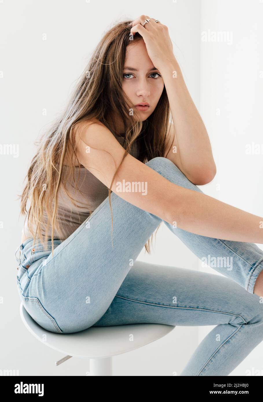 Studio portrait of blonde woman in skinny jeans Stock Photo - Alamy