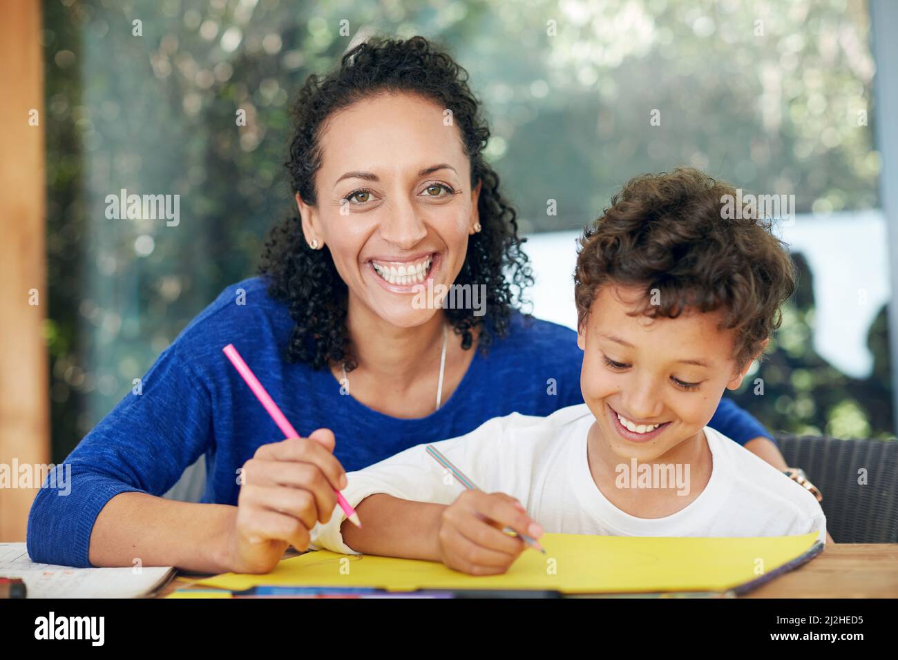 Hes my little artist. Portrait of a mother and son colouring in together at home. Stock Photo