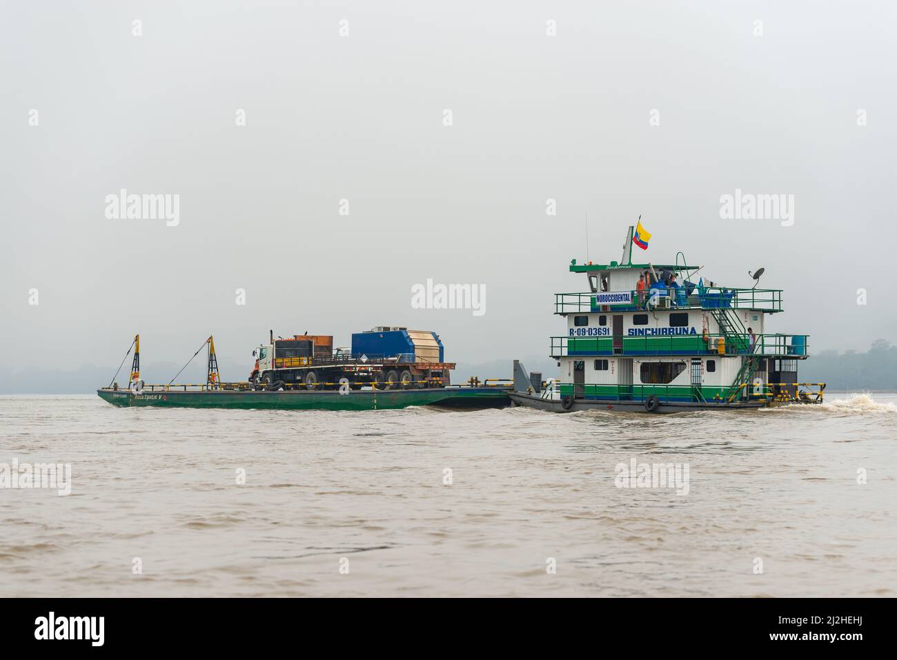 Heavy vehicle transport ship on Napo River for crude oil extraction in the Amazon rainforest, Yasuni national park, Ecuador. Stock Photo