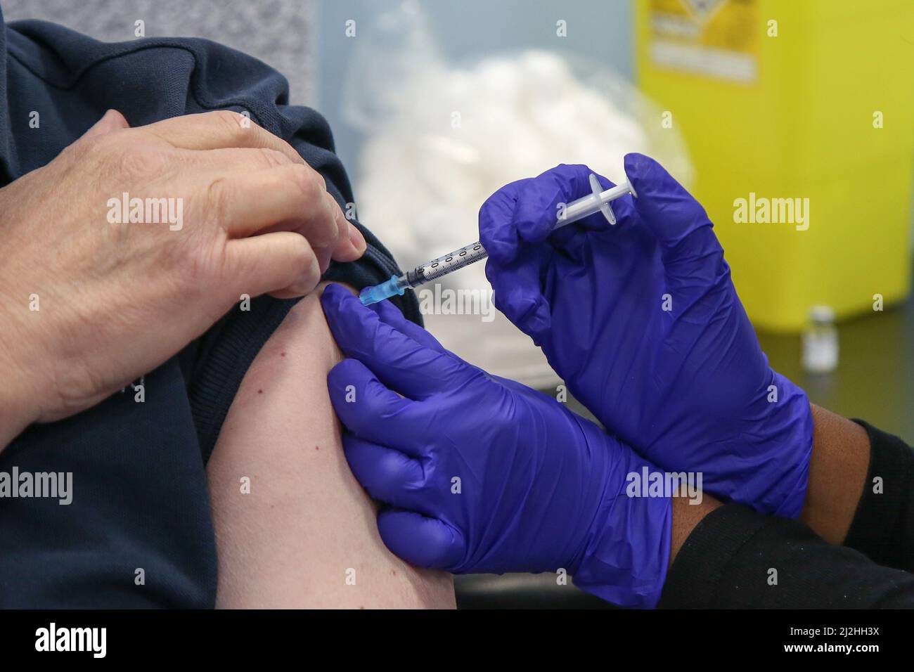London, UK 1 Apr 2022 - A NHS vaccinator, administers the Pfizer COVID-19 second booster jab to a woman, at a vaccination centre in north London. Older adults have been invited for a fourth Covid-19 dose as part of the spring Covid-19 booster campaign. The campaign is being rolled out as immunity from vaccination declines over time, and according to the Office for National Statistics a record 4.9million people in the UK had COVID-19 in week to 26 March. Credit Dinendra Haria /Alamy Live News Stock Photo