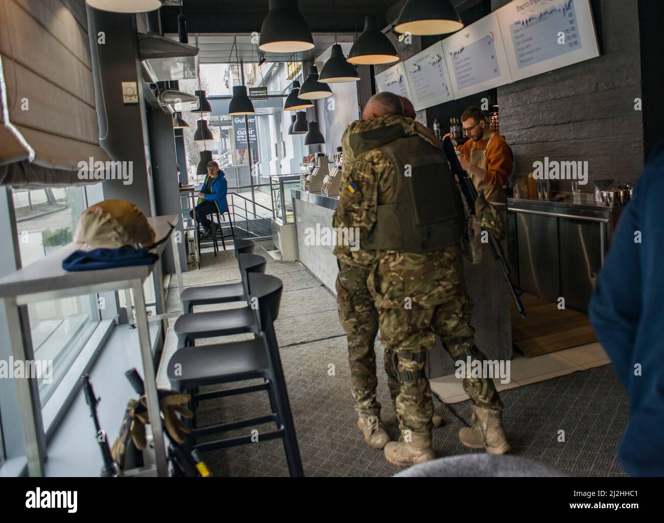 A warm meeting of two friends, defenders of Ukraine in some cafe in Kharkiv, during a time of russian siege of the city Stock Photo