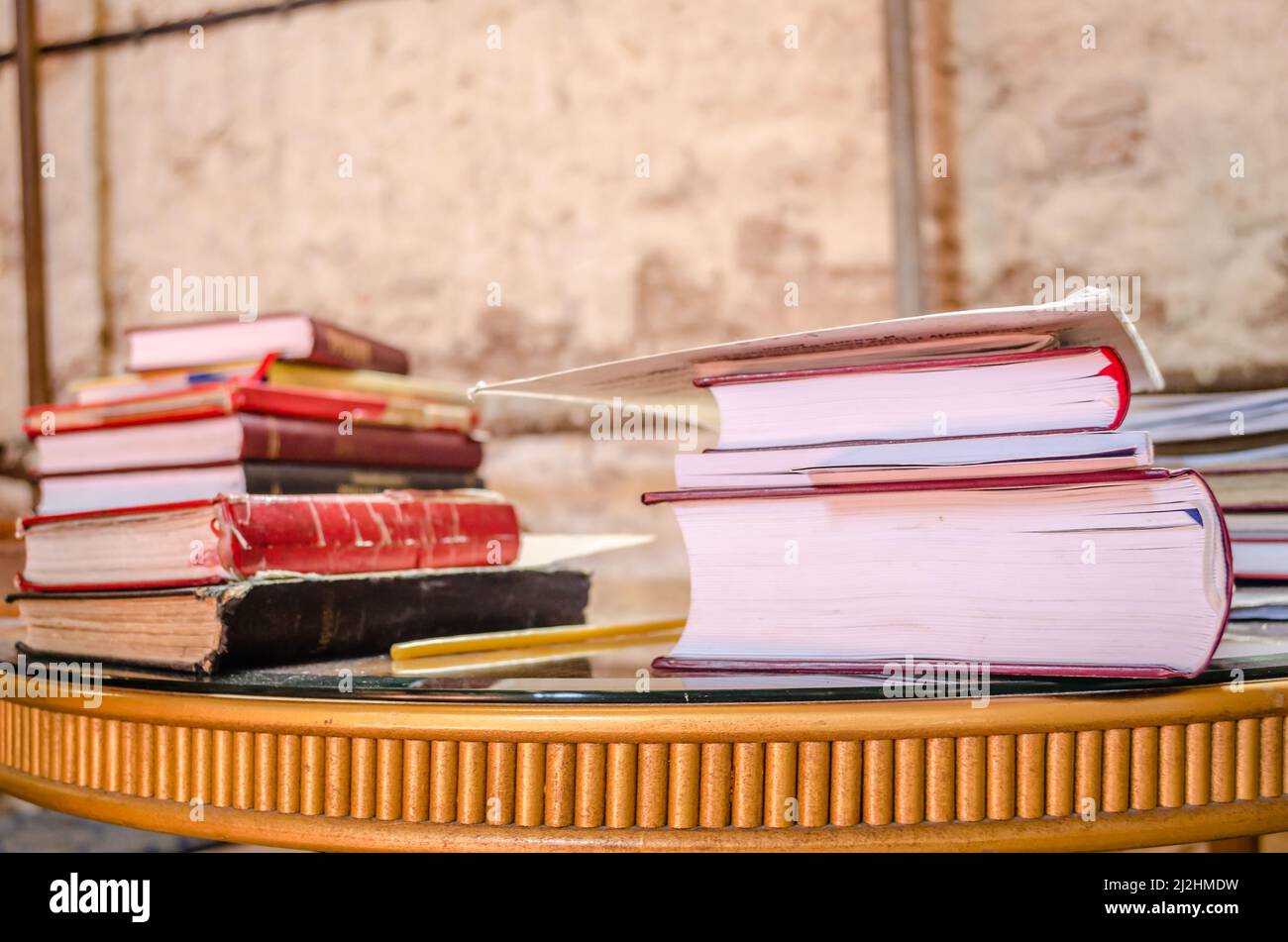 One on top of the other, a pile of stacked old dilapidated books. Stock Photo