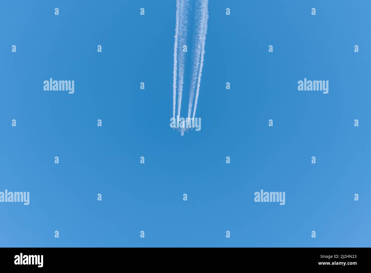 Airplane in a blue cloudless sky with contrails without clouds, Germany