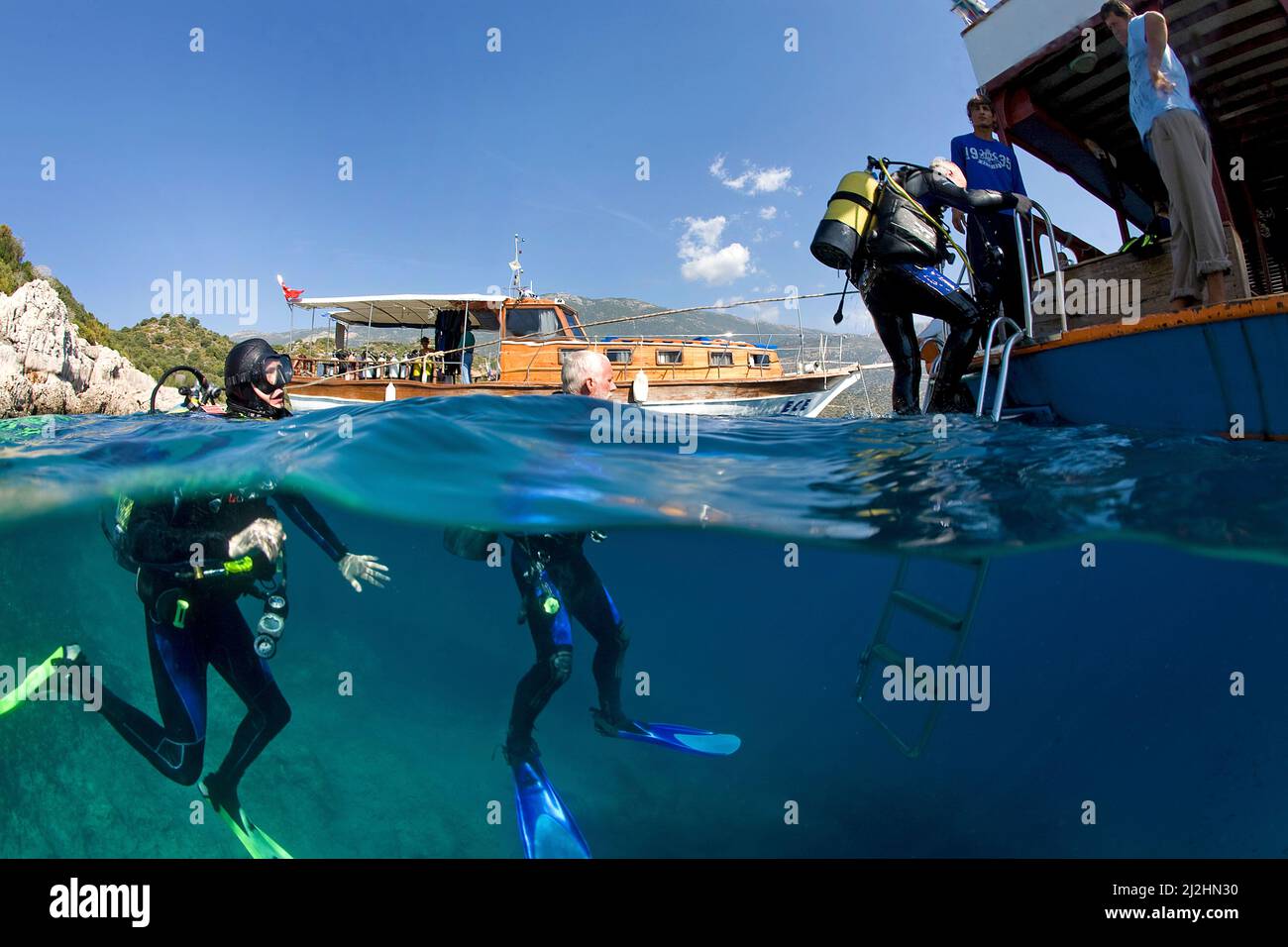 Split image, scuba diver at boat ledder, dive boat of Kas Diving, Kas, Lykia, Turkey, Mediteranean sea Stock Photo