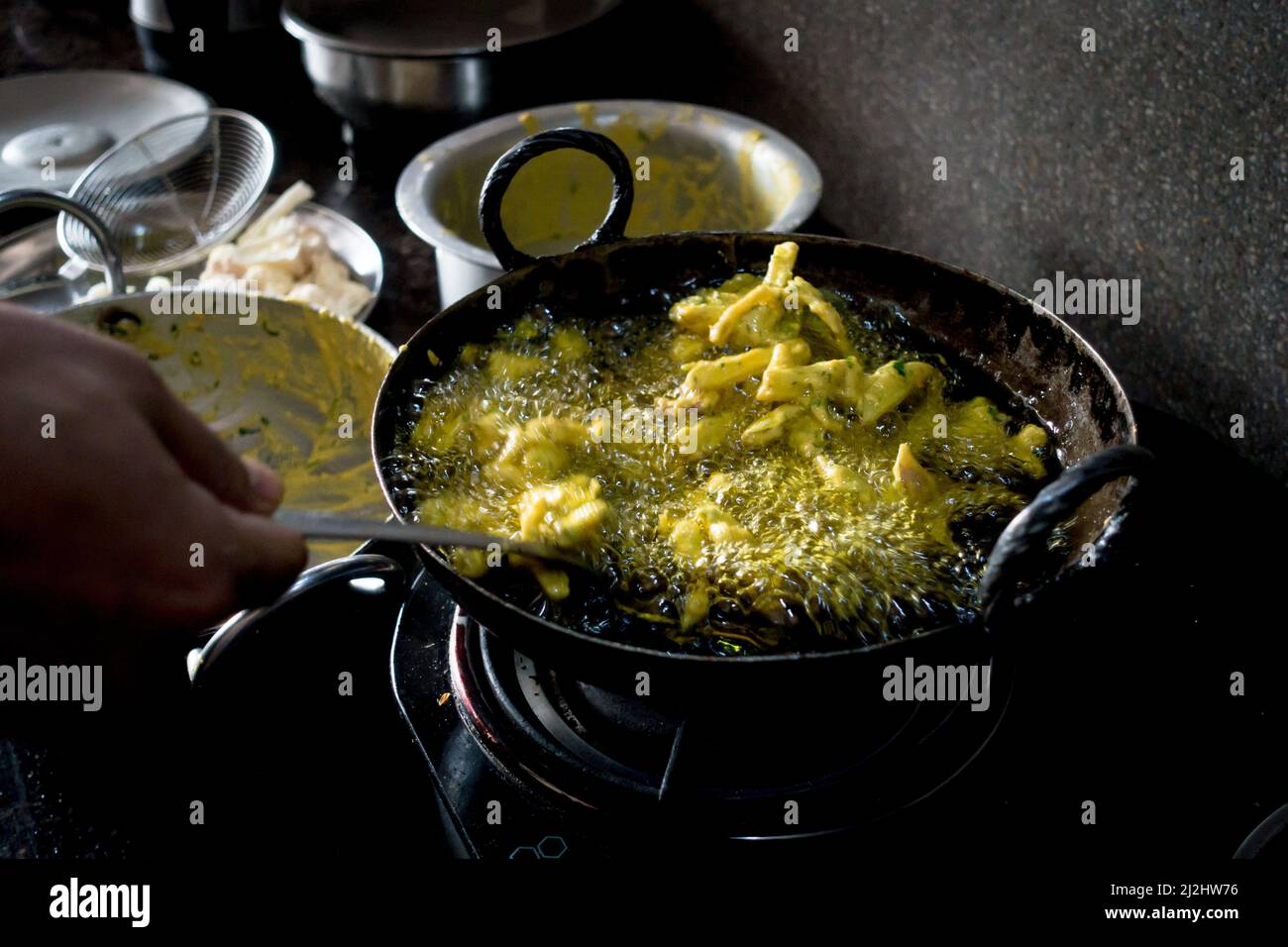 A close up shot of Indian snack called pakoda in making. A deep fried marinated potato recipe. Stock Photo