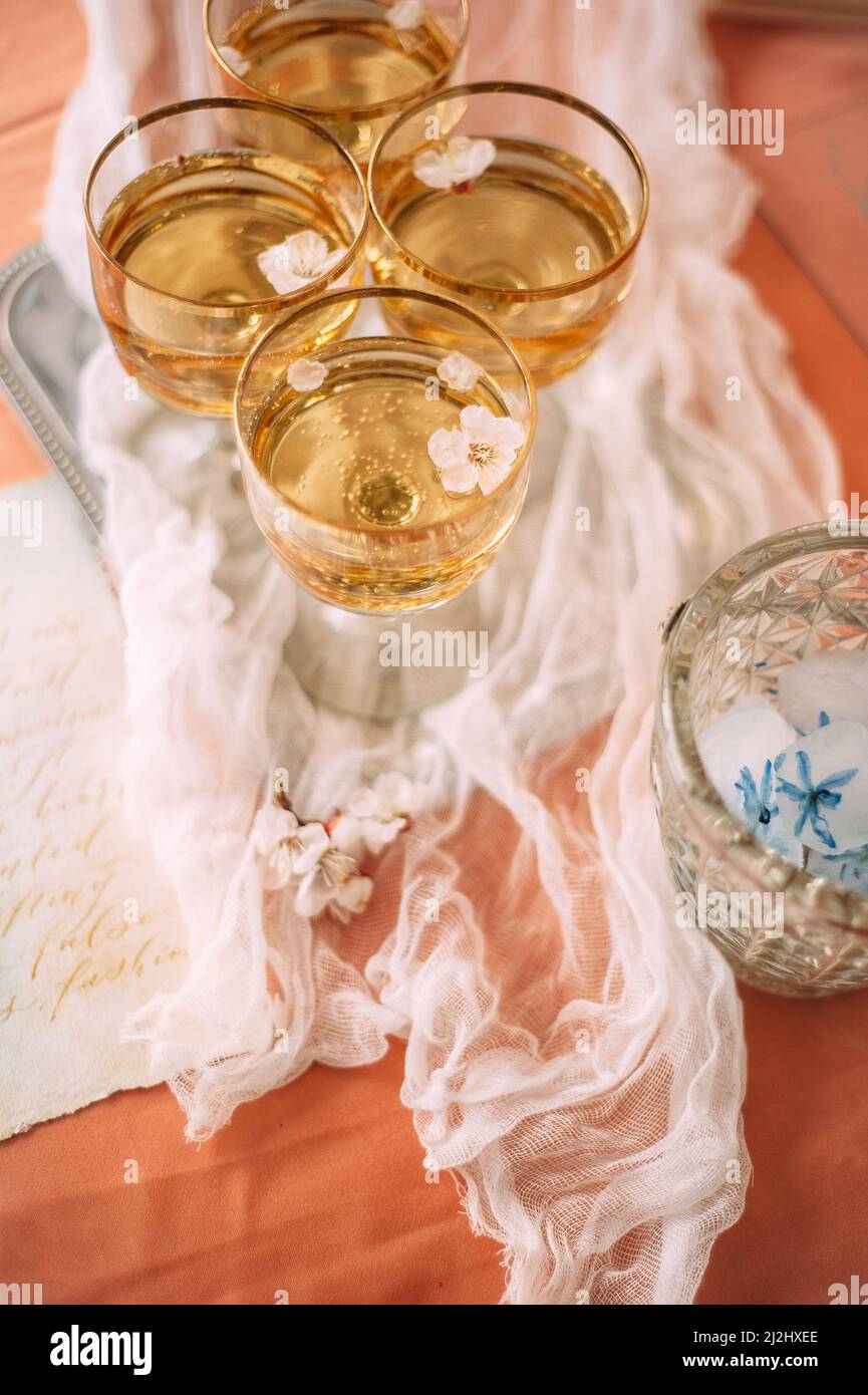 Glasses of champagne on the table, top view, flat lay, catering. Spring or summer wedding party, white flowers. Stock Photo