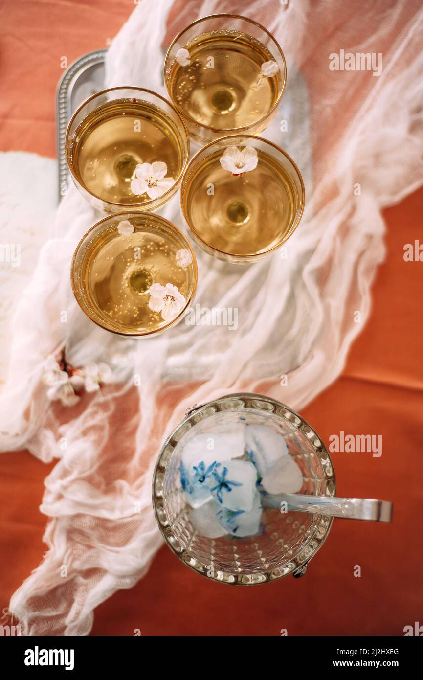 Glasses of champagne on the table, top view, flat lay, catering. Spring or summer wedding party, white flowers. Stock Photo