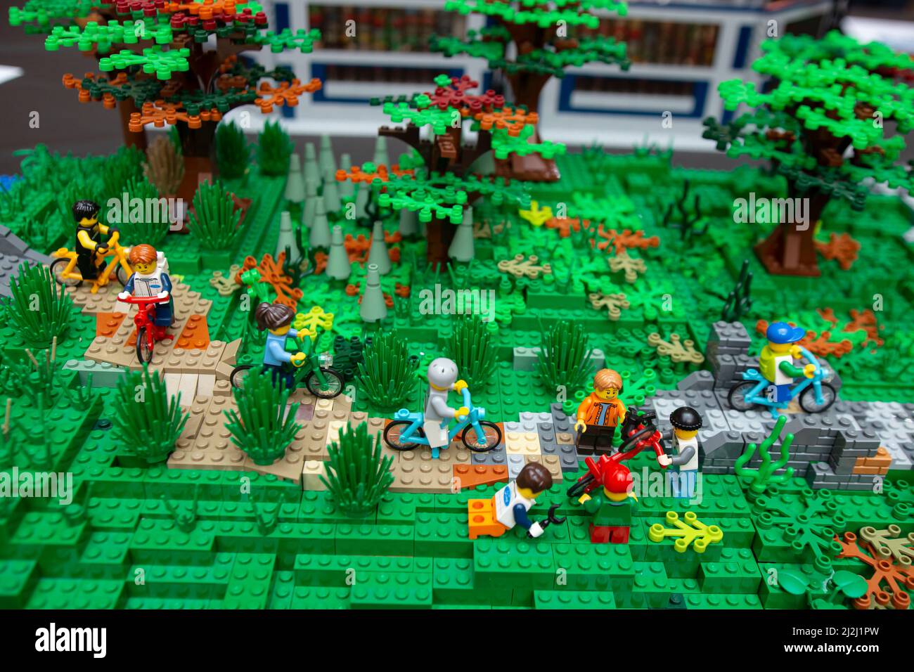 Lego toys scene depicting kids playing in the park, with alleys trees and grass. Stock Photo