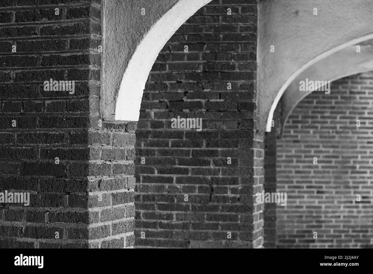 Arcade of vintage brick columns outside on the ground level in black ...