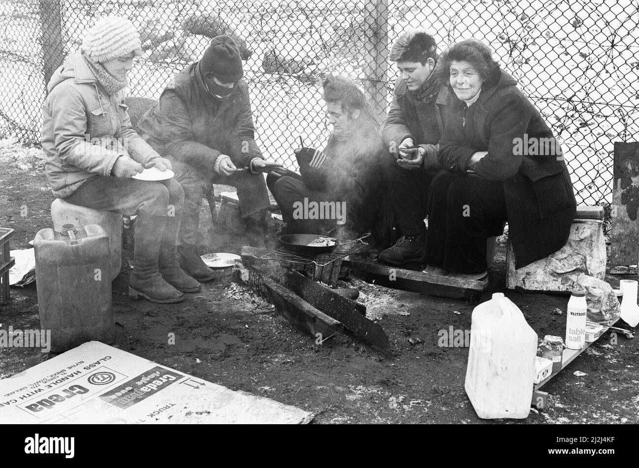Women huddle together around camp fires in the 'Women's Peace Camp' at Greenham Common following a heavy snowfall 12th January 1987 Stock Photo