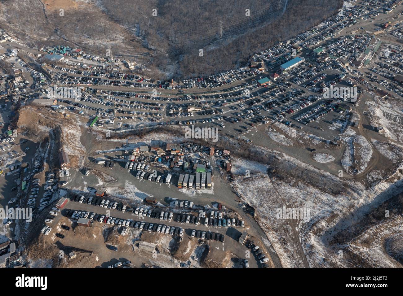 Rows of standing cars at the car market filmed from above. Sale of used cars brought from Japan. Stock Photo