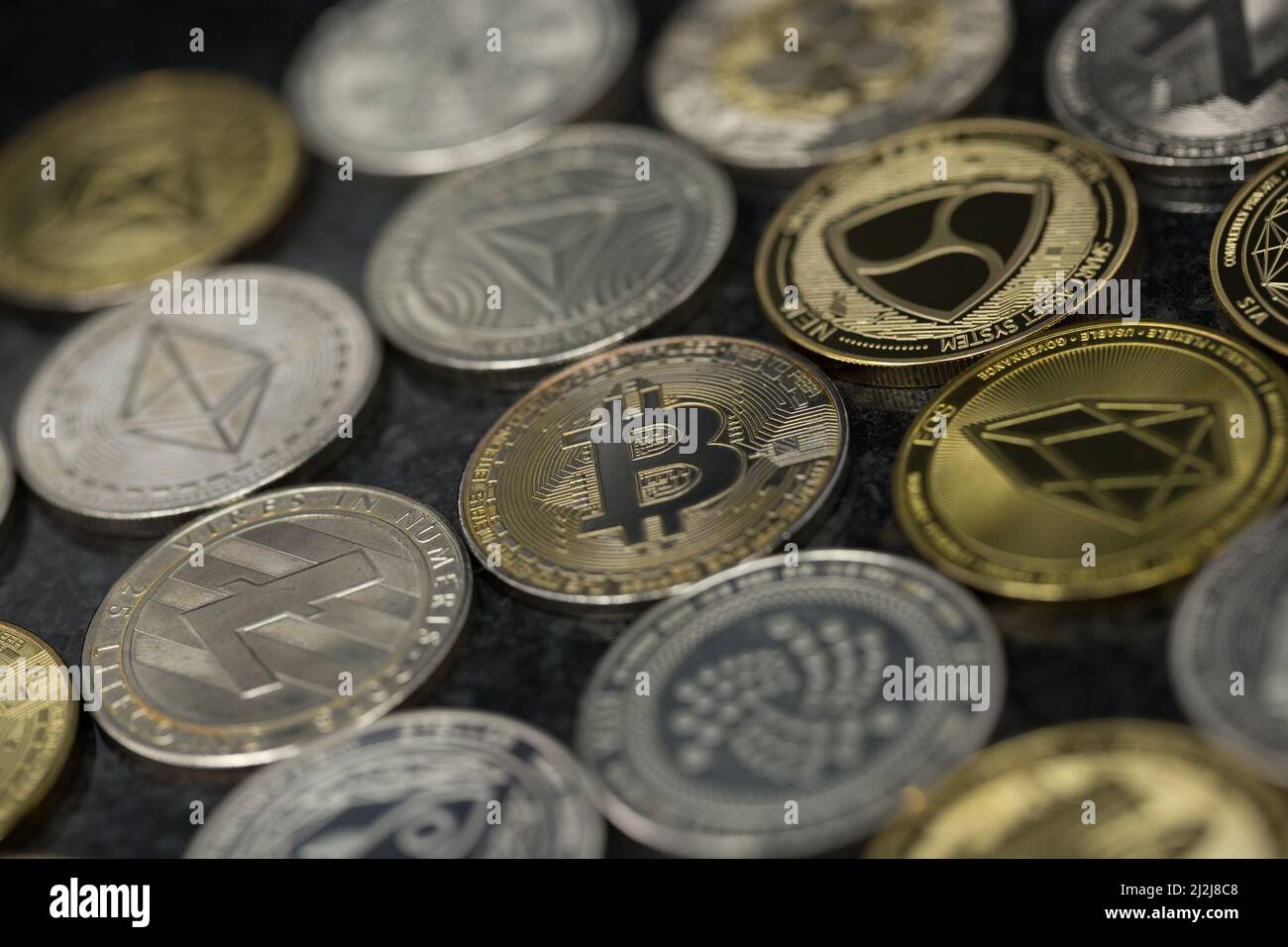 Bitcoin Cryptocurrency physical coin surrounded with variety of other crypto altcoins. Stock Photo