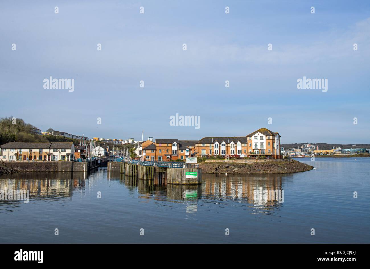 Penarth (old harbour) Marina leading into Cardiff Bay with properties reflected in the still water on a sunny April day Stock Photo