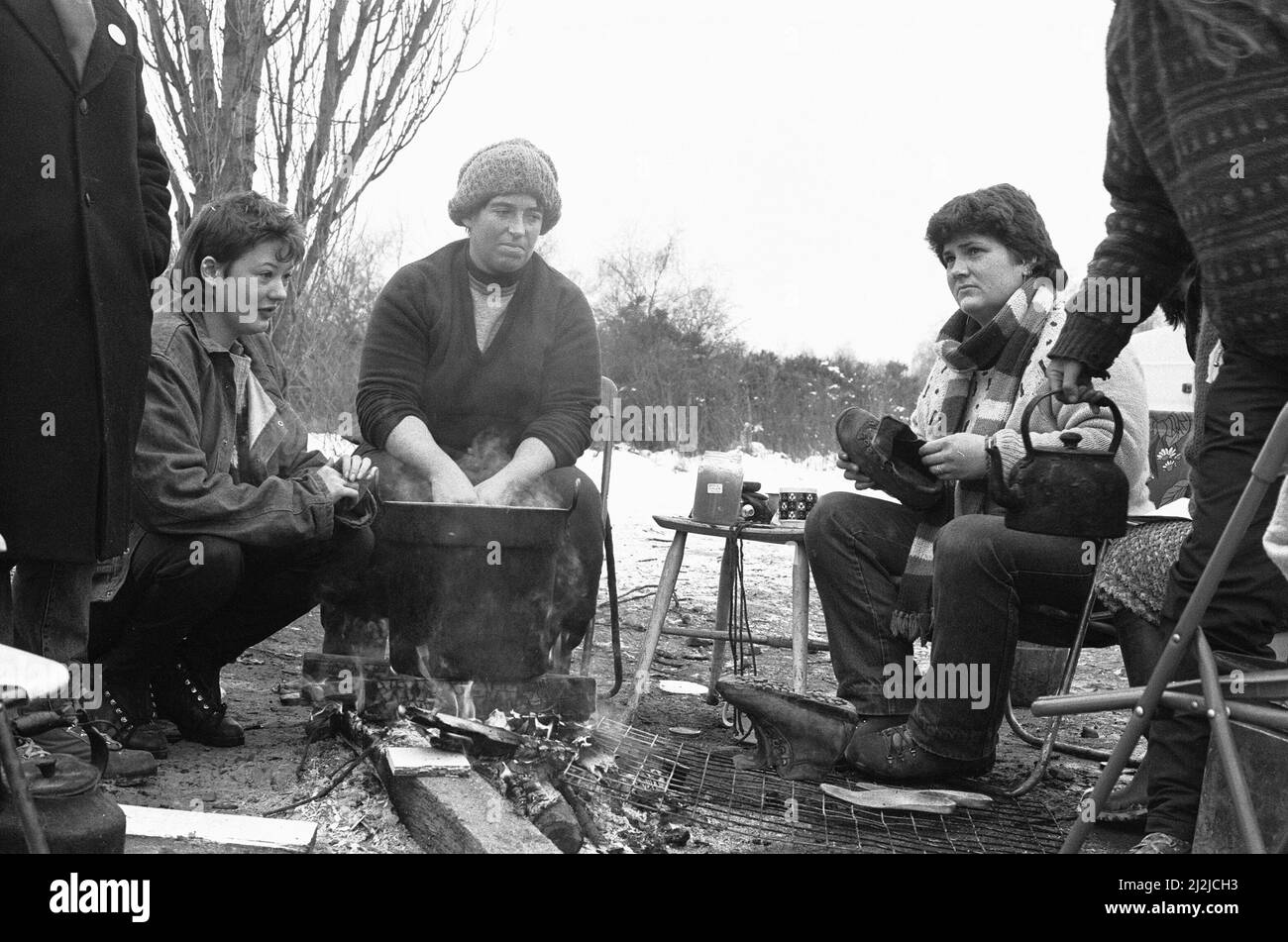 Women huddle together around camp fires in the 'Women's Peace Camp' at Greenham Common following a heavy snowfall 12th January 1987 Stock Photo
