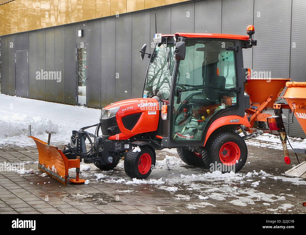 Snow plough parked outside an industrial structure in a winterday with snow Stock Photo