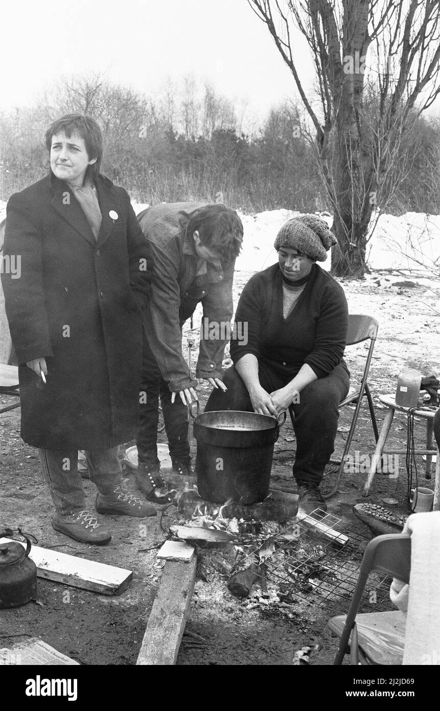 Women huddle together around camp fires in the 'Women's Peace Camp' at Greenham Common following a heavy snowfall 12th January 1987 Stock Photo