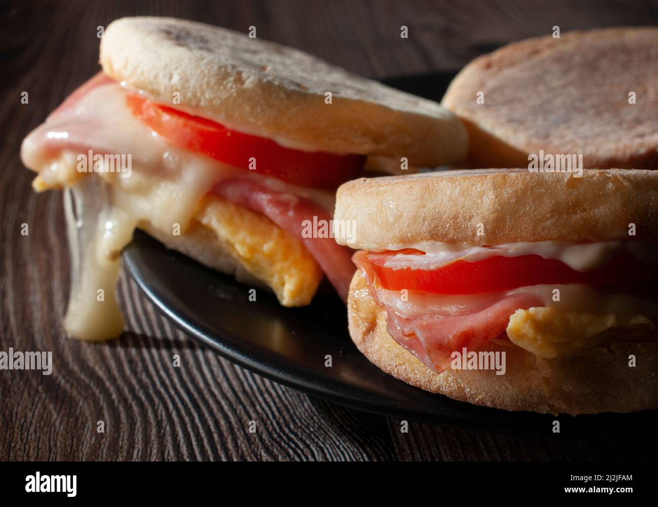 English muffin with egg ham tomato mayo and cheese macro photography