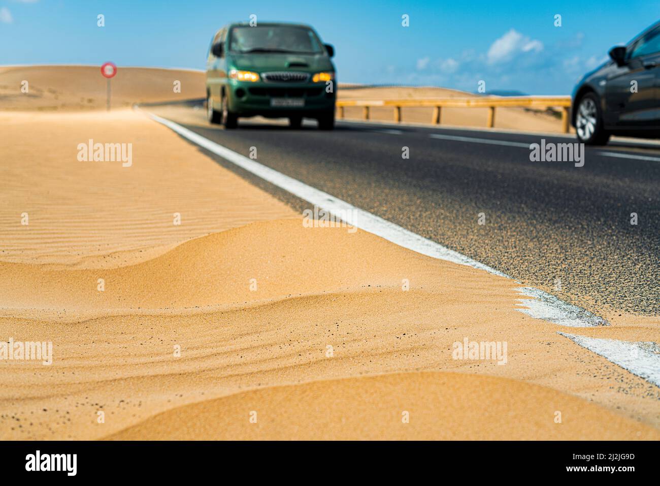 Cars traveling on asphalt road in the desert, Corralejo Natural Park, Fuerteventura, Canary Islands, Spain Stock Photo