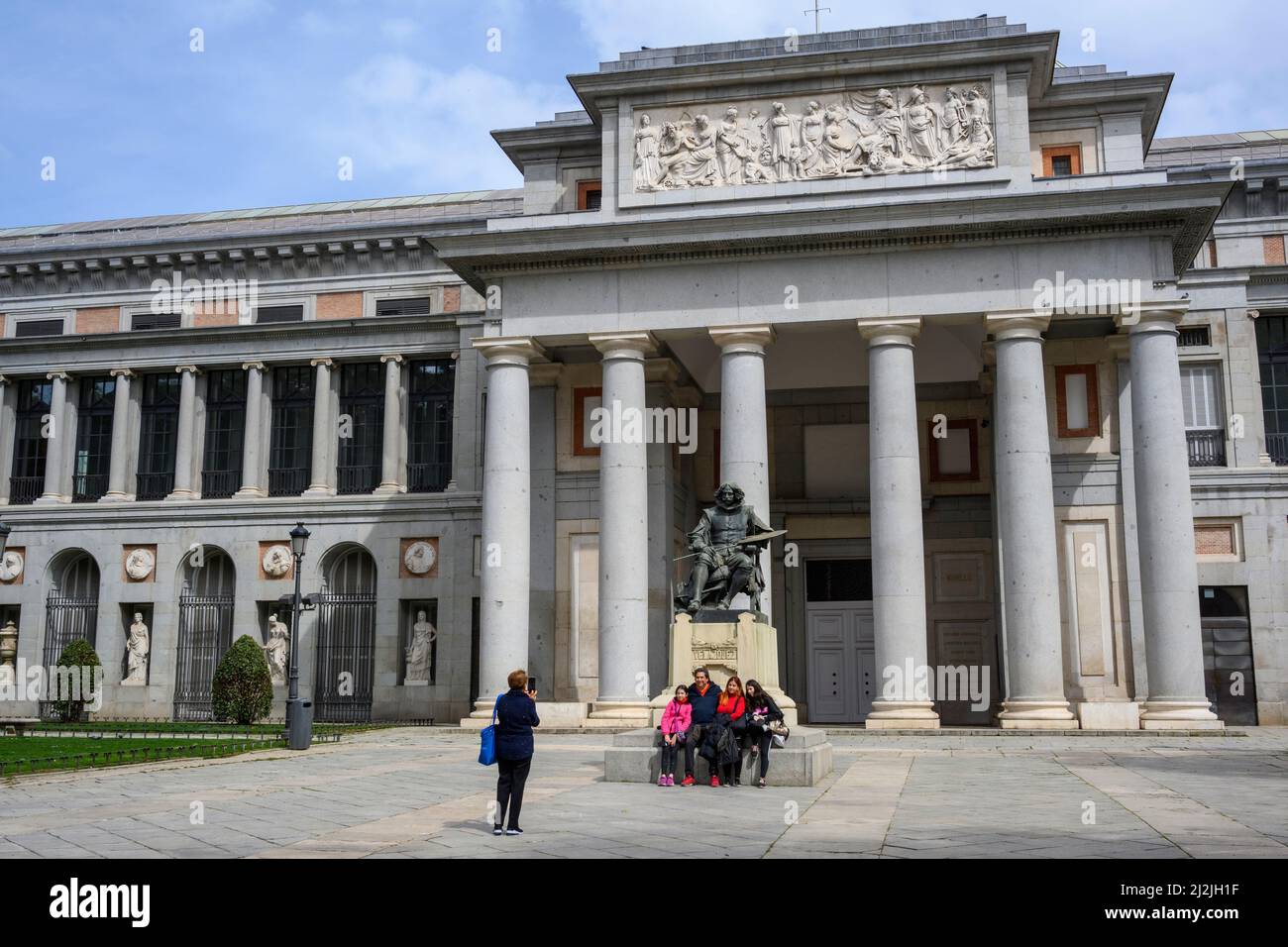 Visitors taking family photo with a statue of artist Diego Velázquez at the entrance to the Prado Musem in Madrid, Spain. Stock Photo