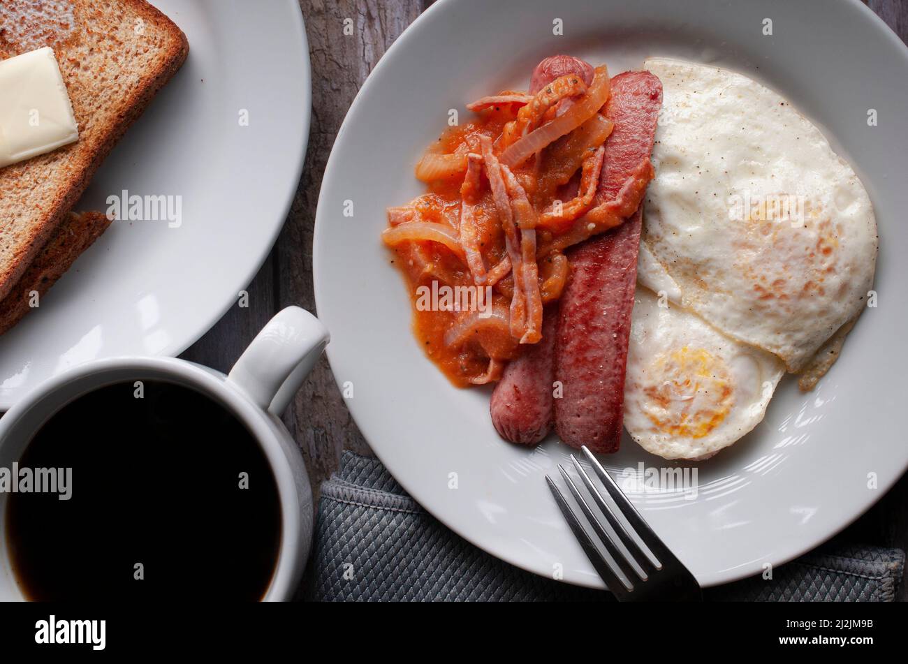 well done fried eggs with sausage and tomato and onion spicy salsa on a