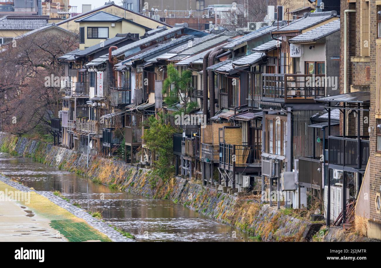 Restaurants in old wooden buildings line Kamo River in Kyoto Stock