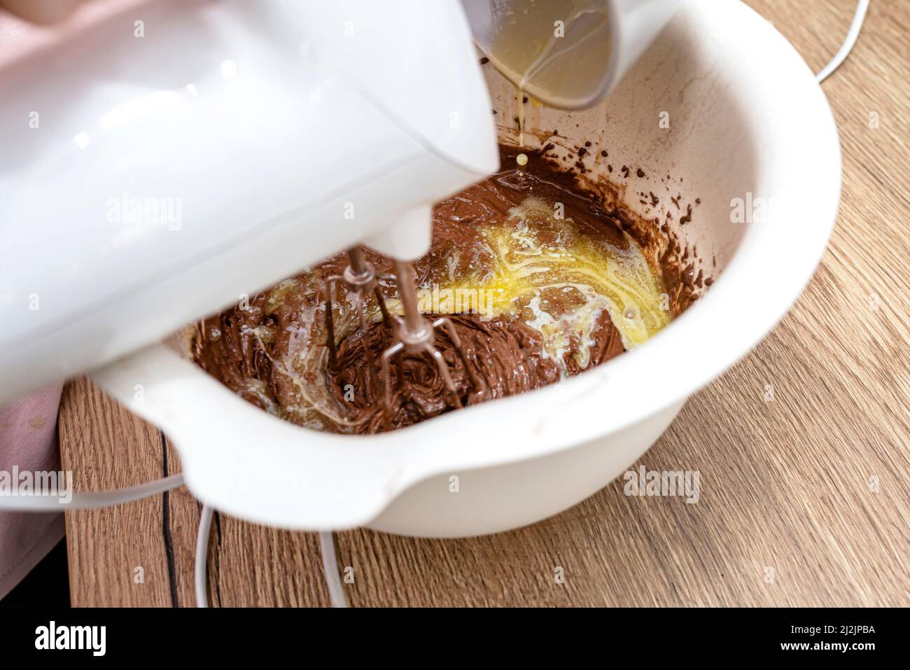 Mixing the dough with a hand mixer with a whisk with melted butter