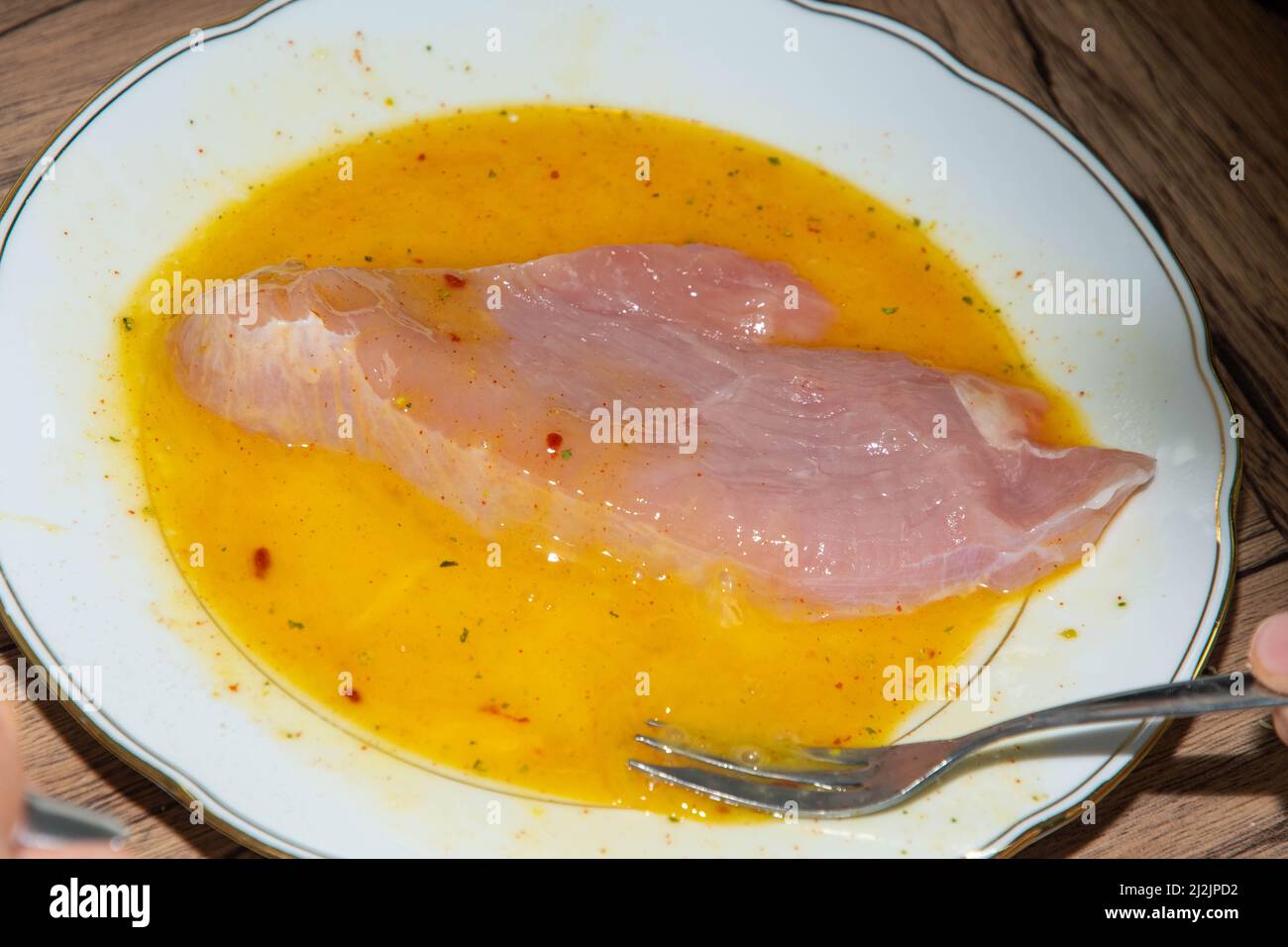 Turkey escalopes in egg yolk for breading Stock Photo Alamy