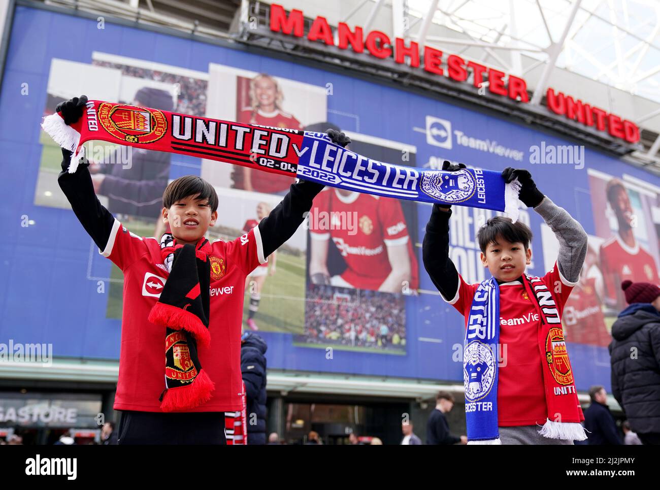 Manchester United fans hold up halfandhalf scarves outside before the