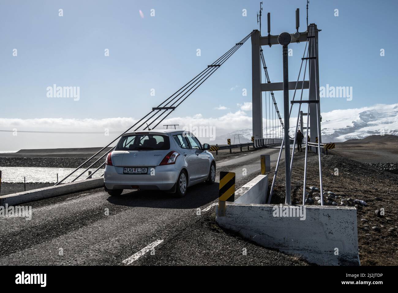 A silver Suzuki Swift crosses the bridge at Jokulsarlon, iceland Stock Photo