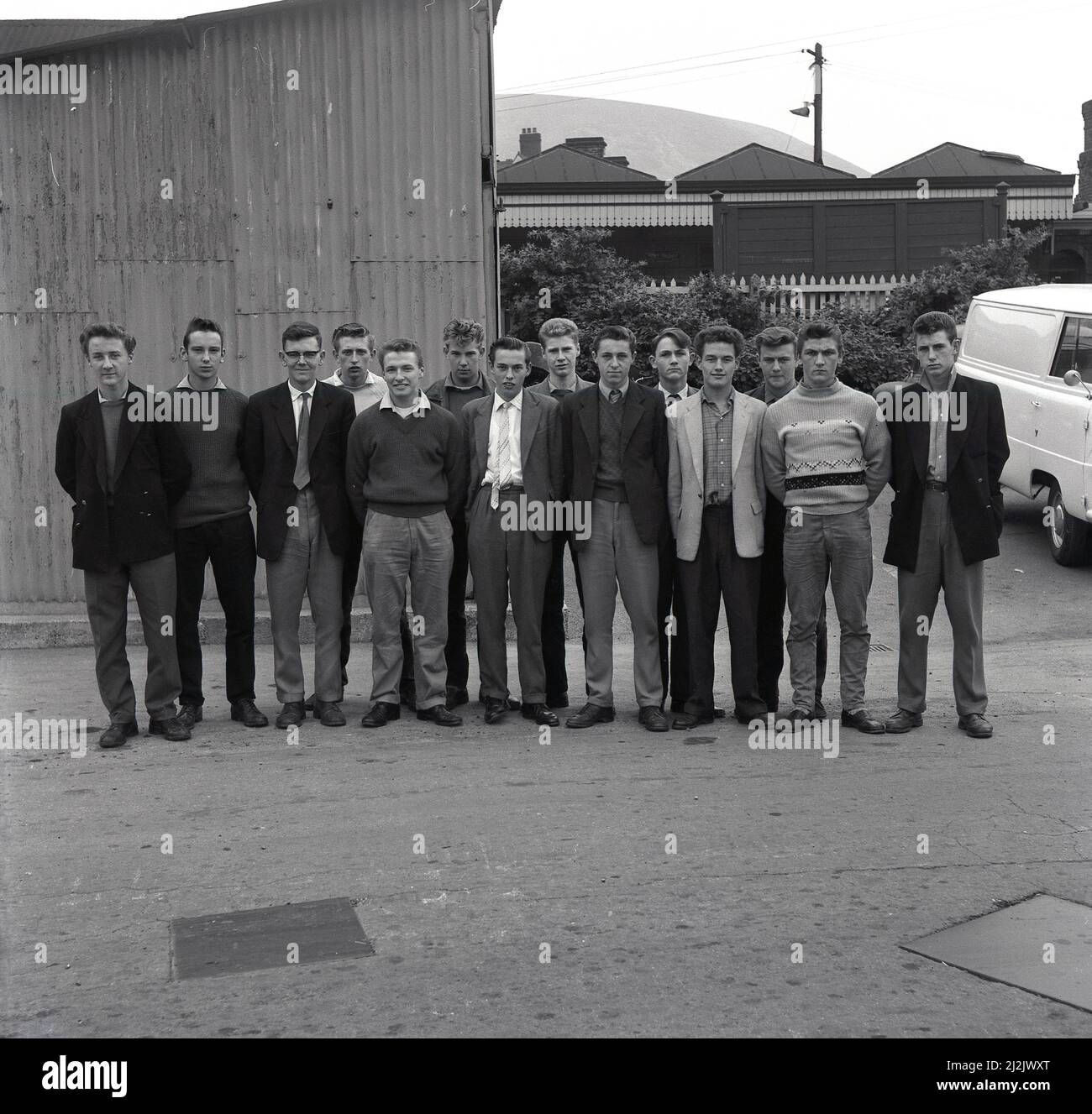1950s, historical, a group of young male industrial apprentices stand outside the railway station at Port Talbot railway station for a photo. They will be working at the newly built Abbey Works plant at Port Talbot for the Steel Company of Wales, a company formed in the post war years to modernise steel production in Britain. Port Talbot would become known as the 'city of steel'. Stock Photo