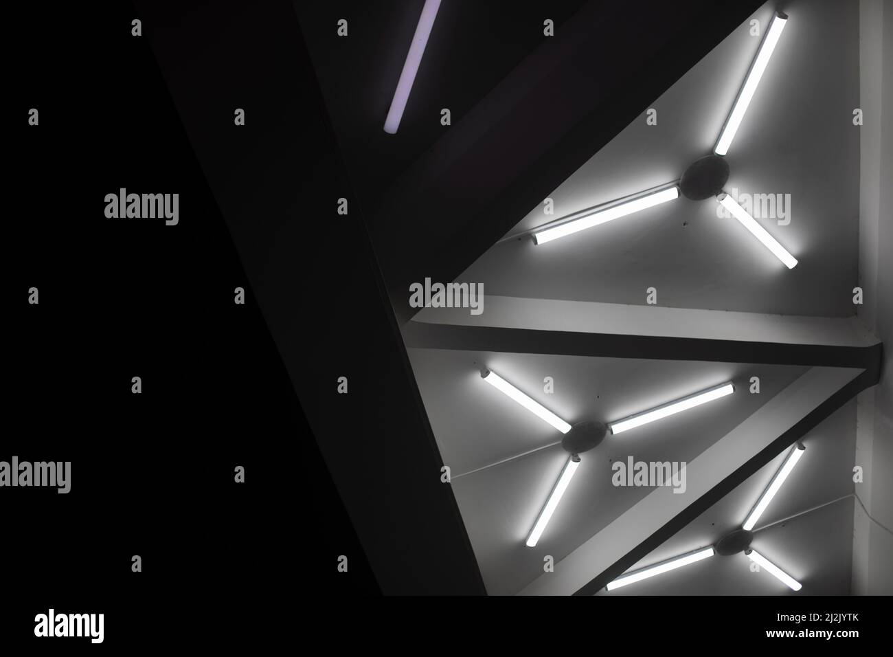 Light design. Fluorescent lamps on ceiling. Triangles of lamps
