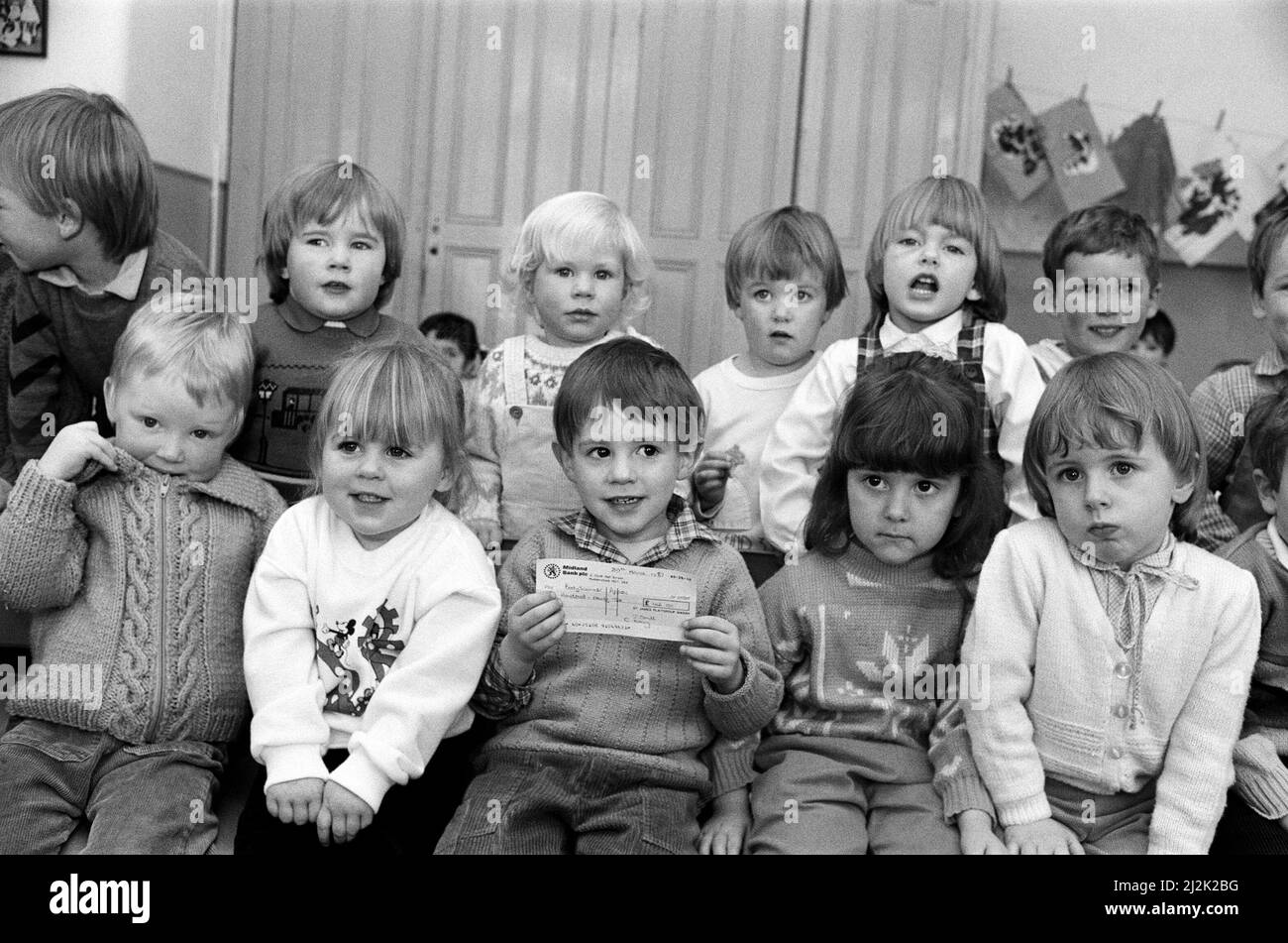 St James's Playgroup at Marsh raised £145 for the £1/2m Examiner Bodyscanner Appeal with a coffee morning, bring and buy sale and cake and toy stalls. Young Jonathan Morris and fellow members are pictured with the cheque. The event was held at St James's Parish Hall, Marsh. 1st April 1987. Stock Photo