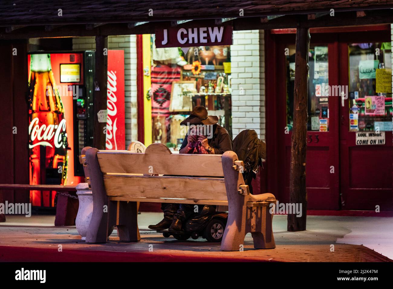 Homeless man wearing cowboy hat blowing his nose in front of a tabaco shop in downtown Scottsdale, Arizona, United States. Stock Photo