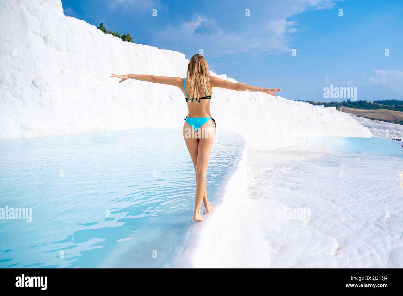 Pamukkale Turkey Tourist young woman in swimsuit background travertine pools blue water denizli. Concept natural spa treatment for skin. Stock Photo