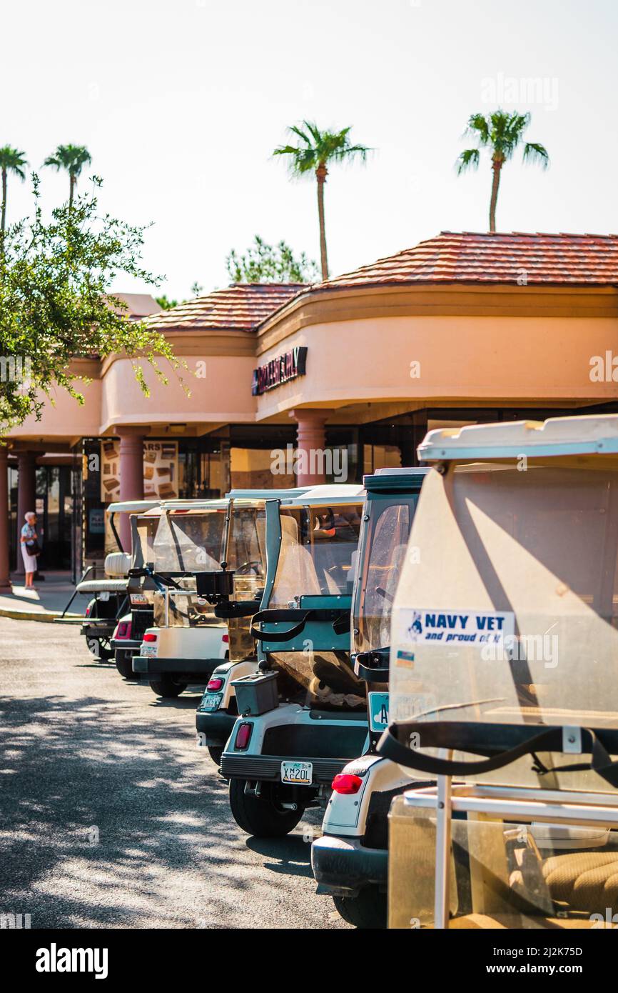Row of golf carts parked at a strip mall parking lot in Sun City, Arizona, United States. Stock Photo