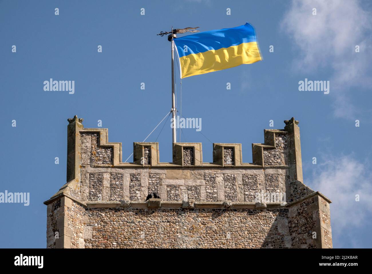 The Ukrainian People's Republic bicolour flag flying from the church tower of St Peter and St Paul's, Aldeburgh, Suffolk. In bright sunshine. Stock Photo