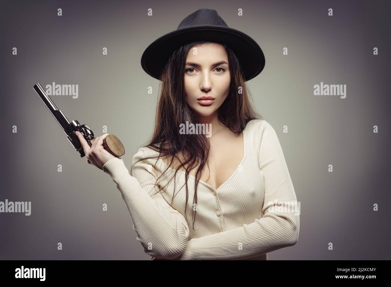 young beauty with a revolver in her hand Stock Photo