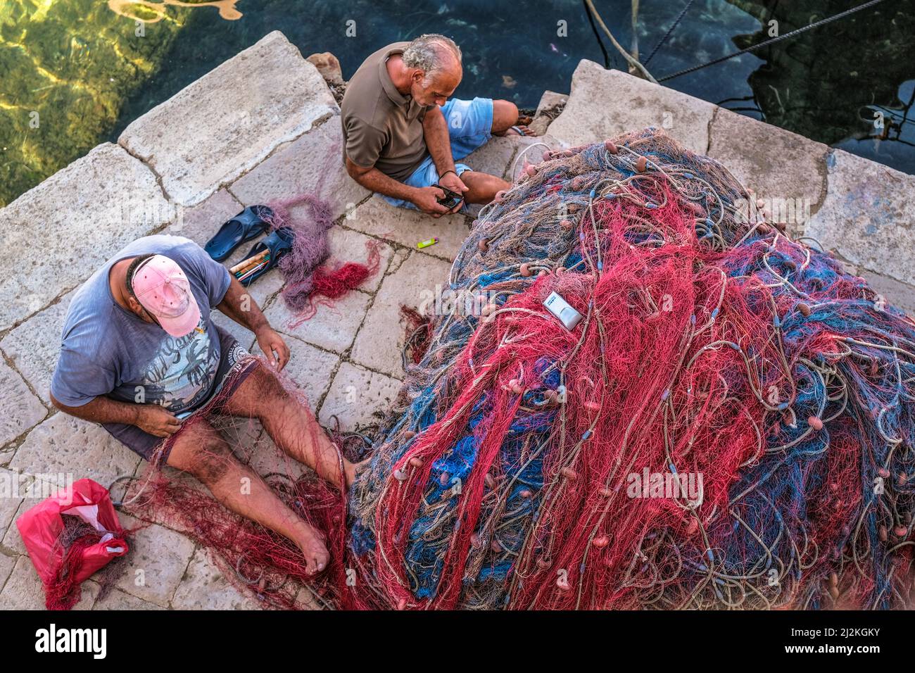 Italy Puglia. Gallipoli. Fishermen mend their nets Stock Photo