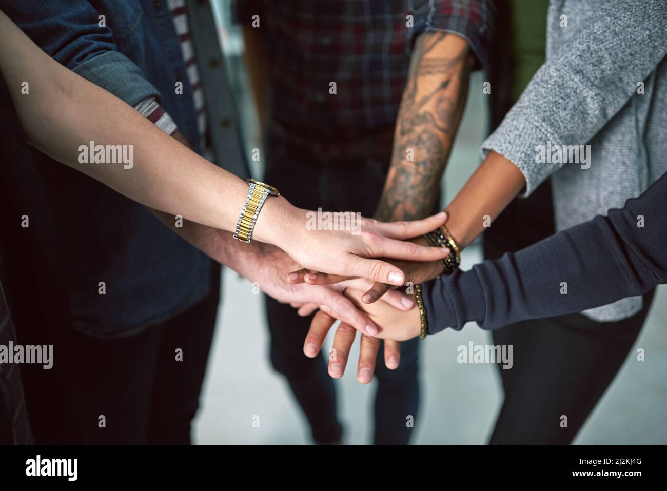 Hands in, everyone. Cropped shot of a group of people stacking their ...