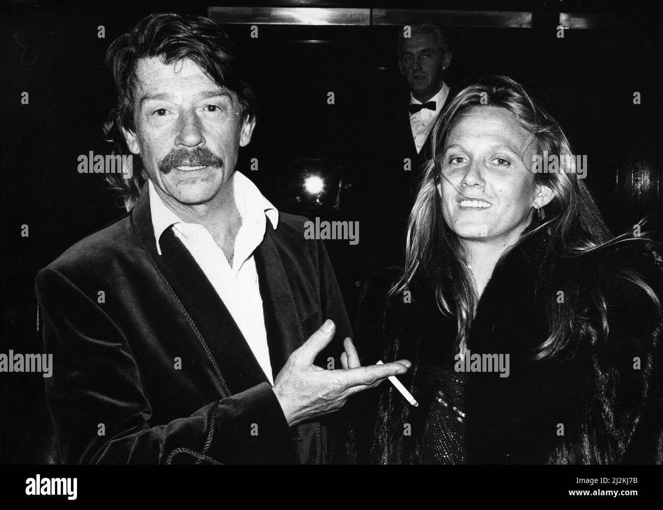 British actor John Hurt arrives at the Royal Albert Hall in London with his wife Donna to attend the musical 'The Hunting of the Snark' based on Lewis Carroll's poem.It was written by composer Mike Batt with John Hurt providing the narration. 1st April 1987. Stock Photo