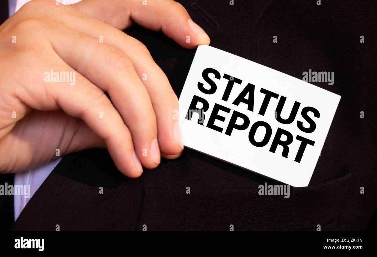 businessman holding a card with text status report. Stock Photo