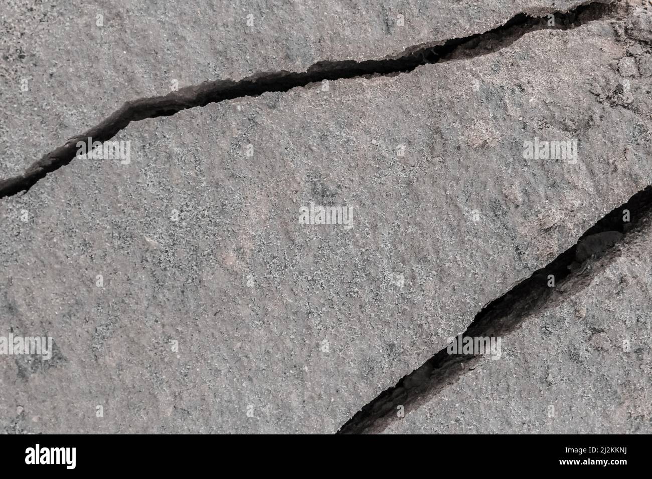 Large crack after earthquake on the soil surface of the earth damaged ground background climate pattern. Stock Photo