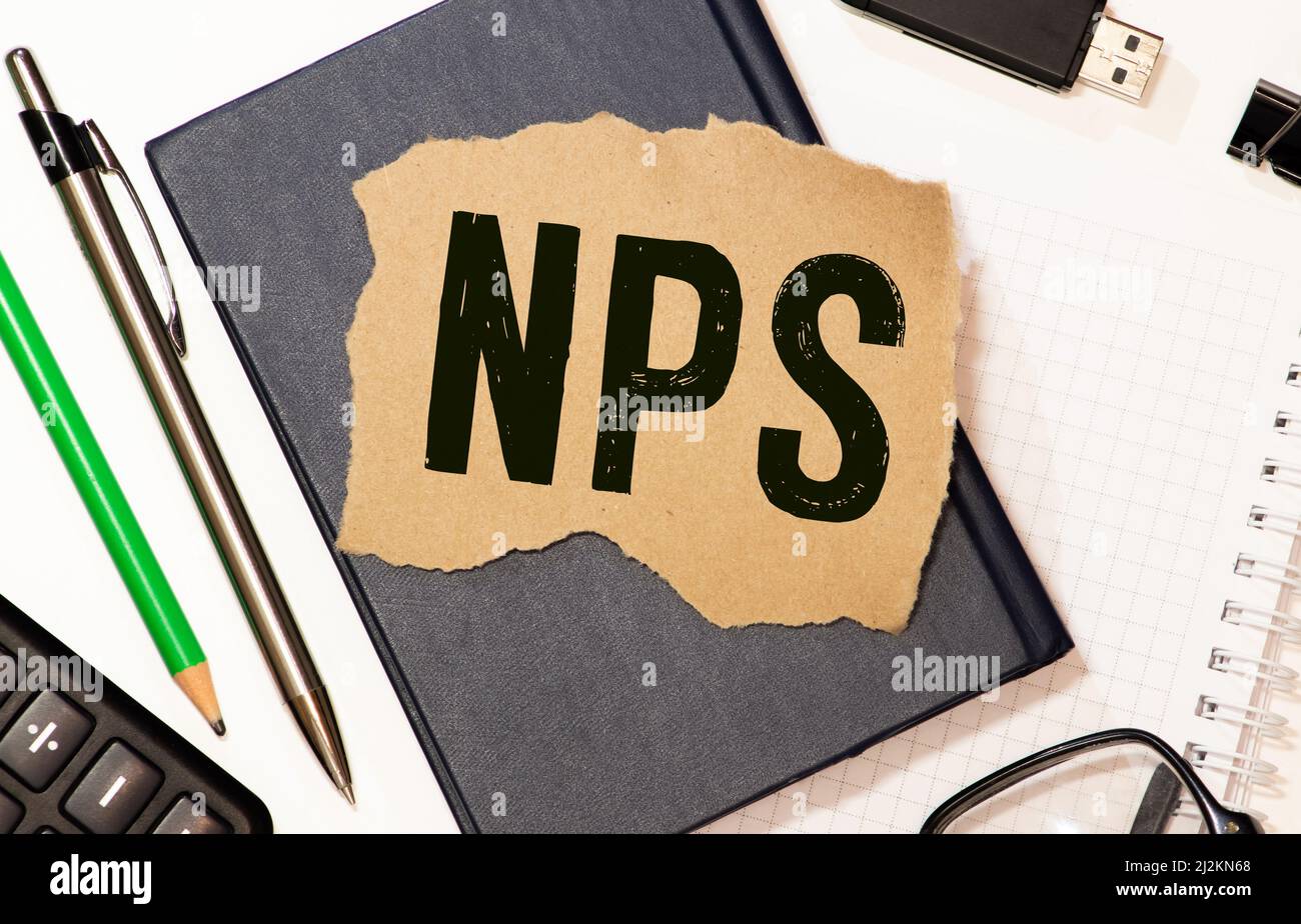 Closeup on business woman holding a card with NPS NET PROMOTER SCORE message, business concept image with soft focus background Stock Photo