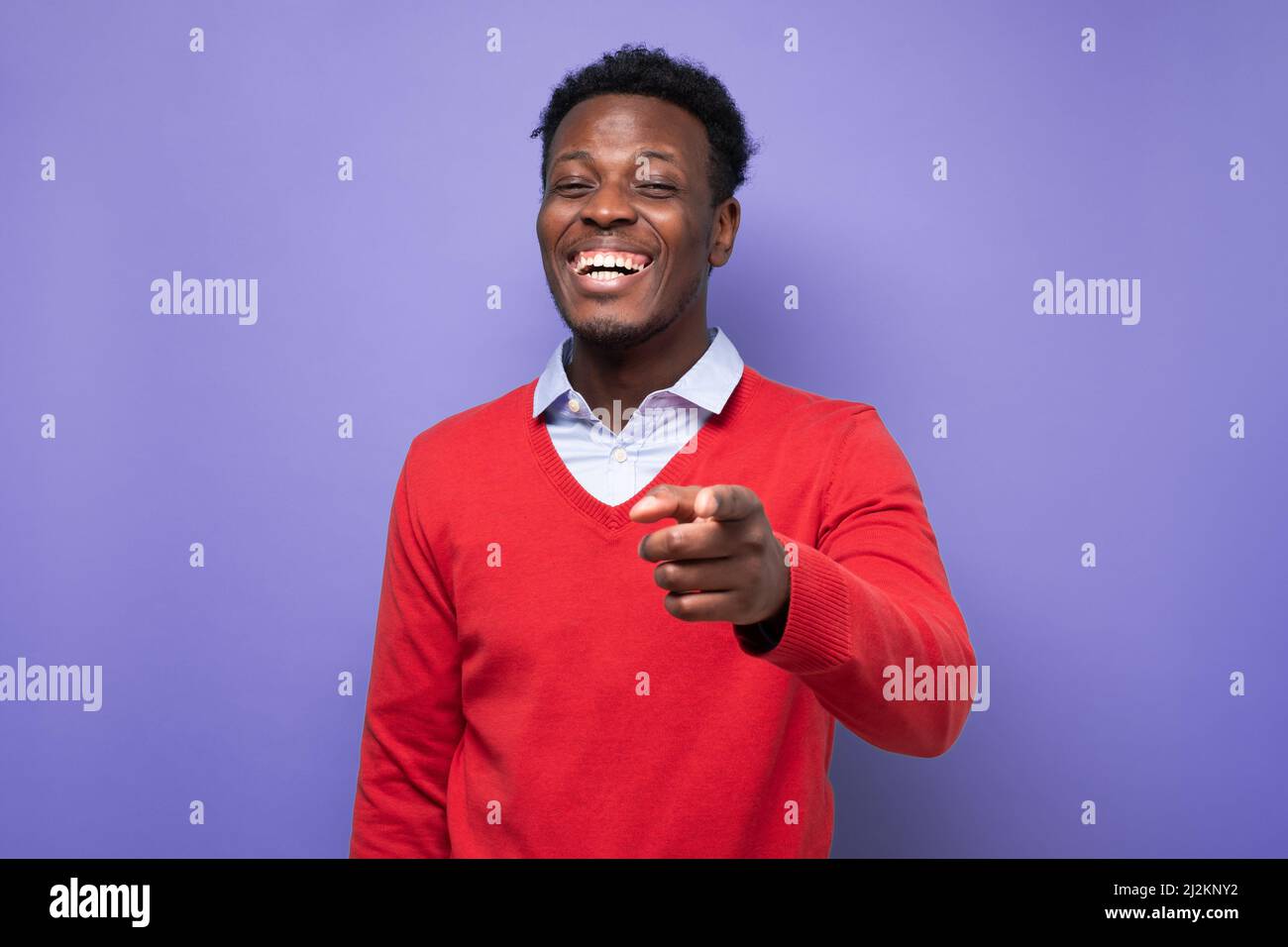 Laughing young african american man pointing index finger on camera ...